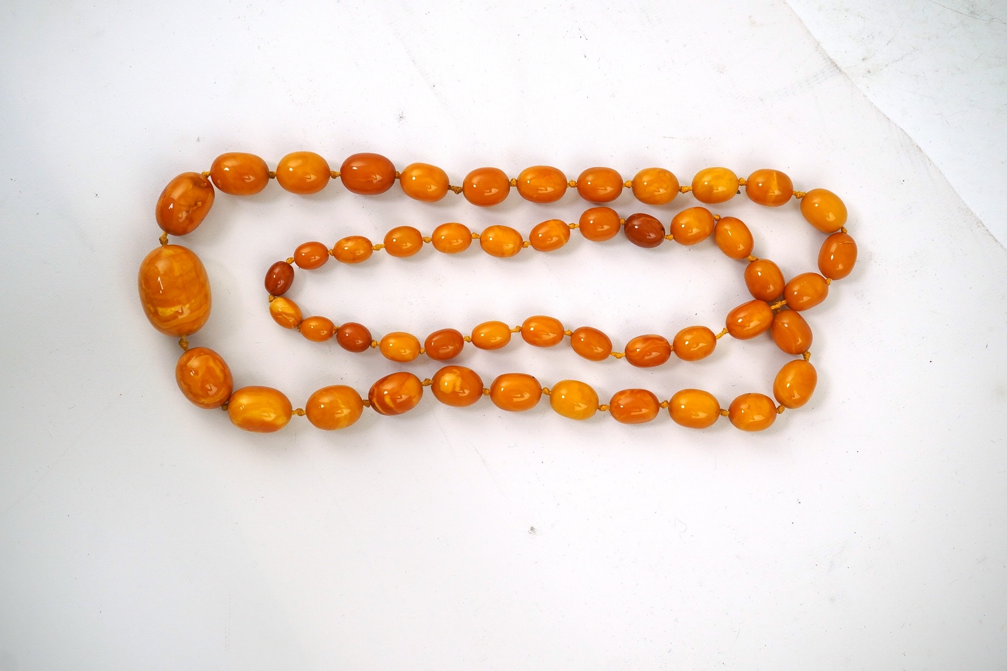 A single strand graduated oval amber bead necklace